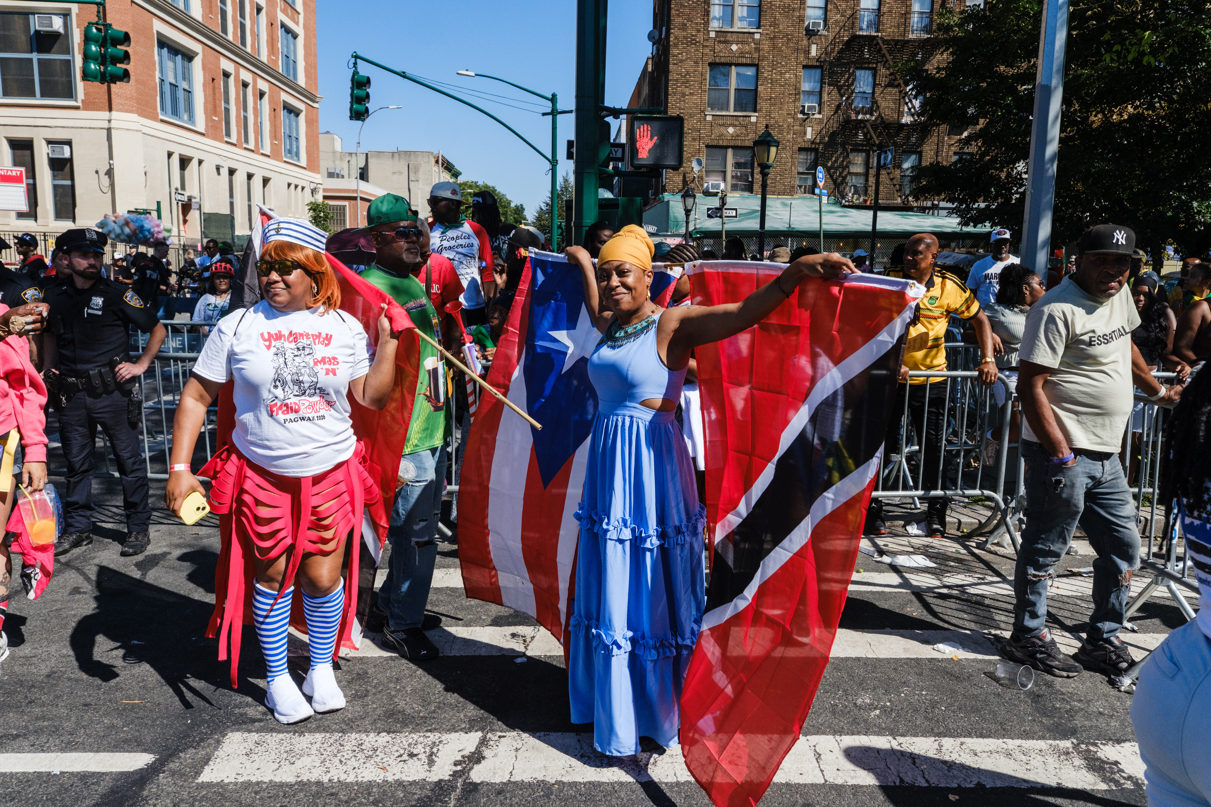 People attending the West Indian Day Parade holding flags from various Caribbean nations.