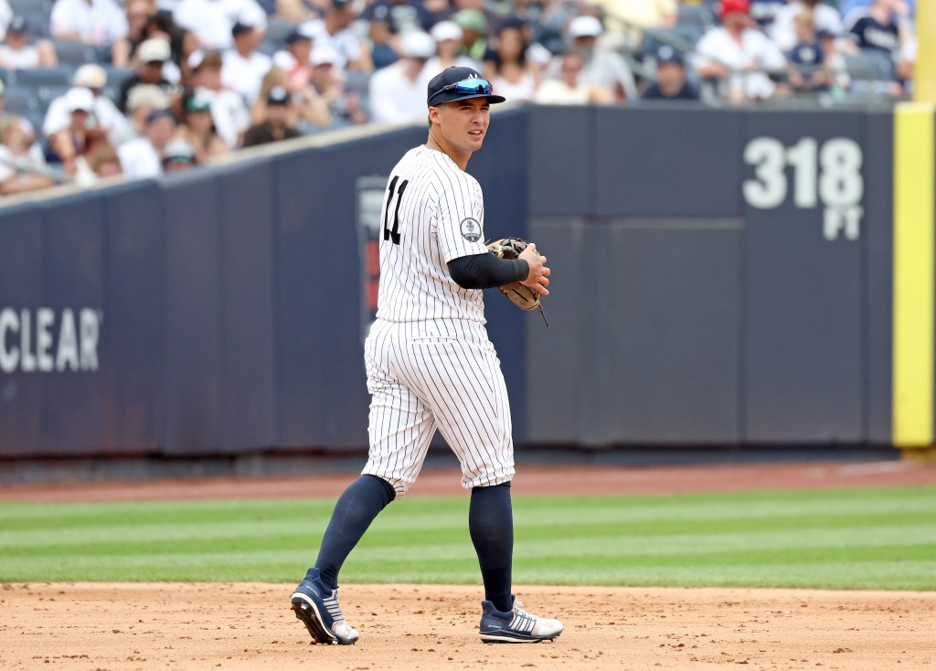 A New York Yankees player in a pinstriped uniform on a baseball field.