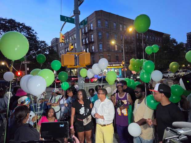 Friends and family of Lovay Williams are pictured during a balloon release for her in Harlem on Monday.