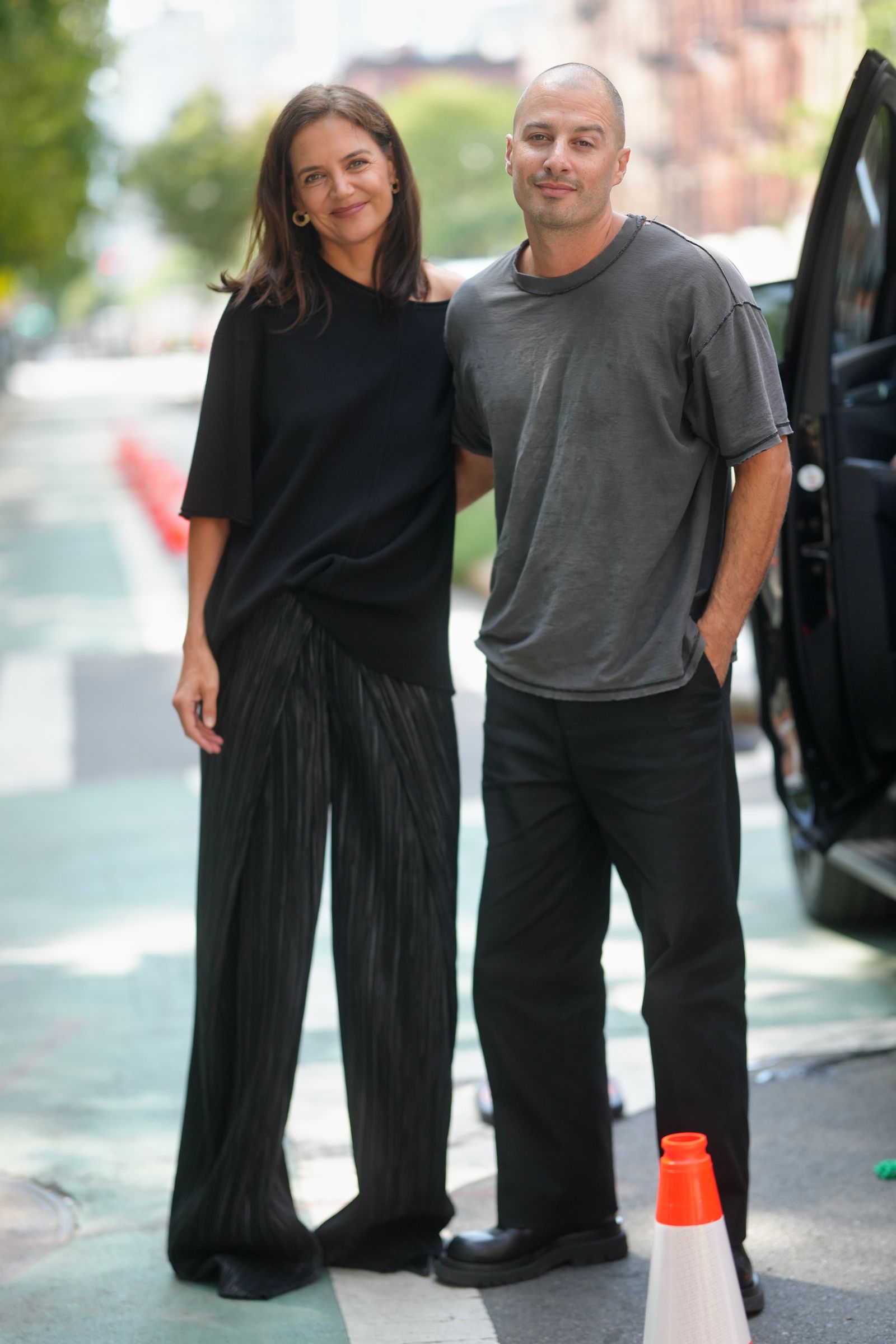 NEW YORK NEW YORK SEPTEMBER 09 Katie Holmes is seen wearing gold hoop earrings black shortsleeve top black pleated...