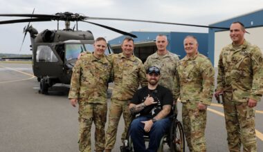 Man in wheelchair with soldiers and helicopter