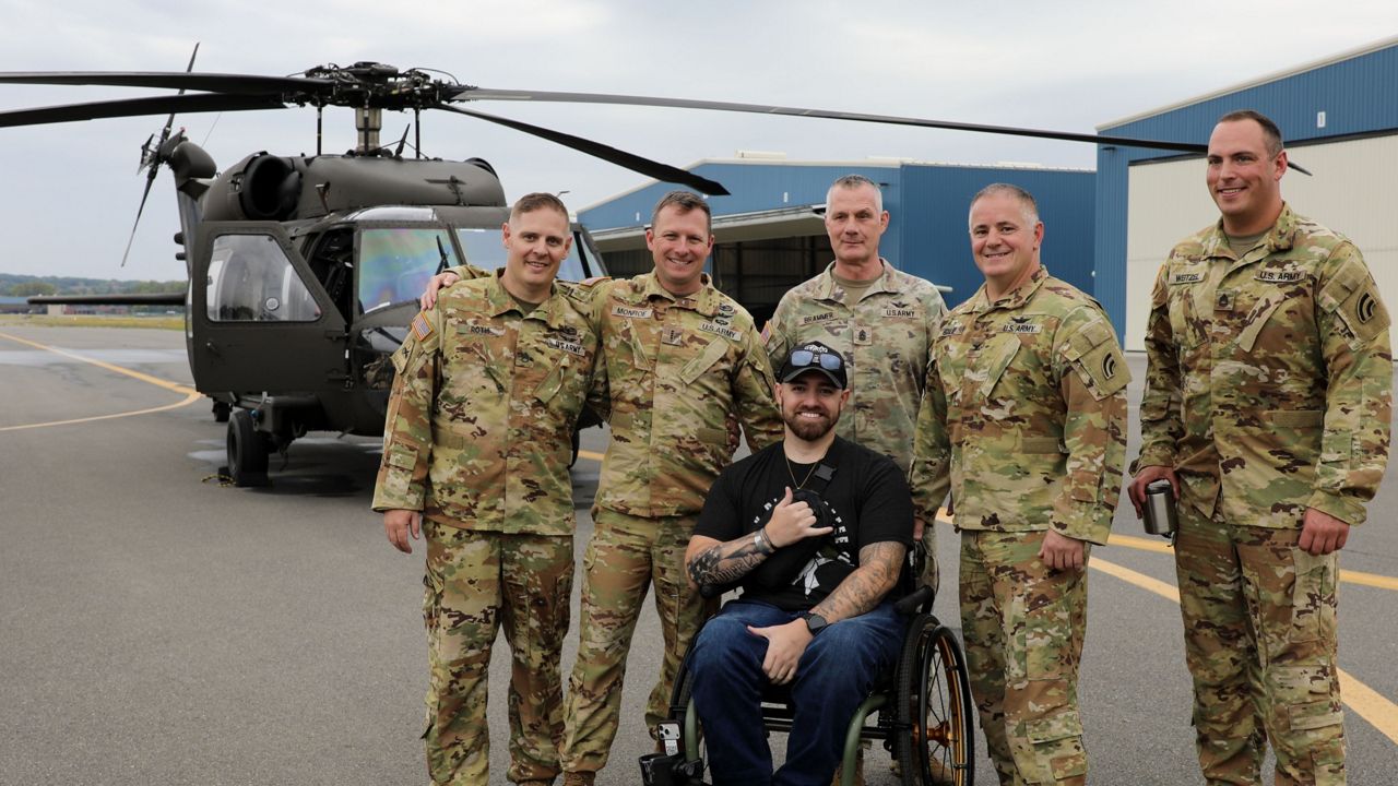 Man in wheelchair with soldiers and helicopter