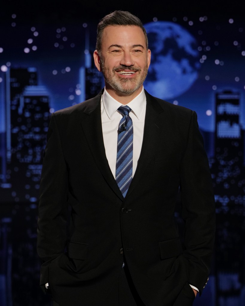 Jimmy Kimmel smiling in a suit and striped tie.