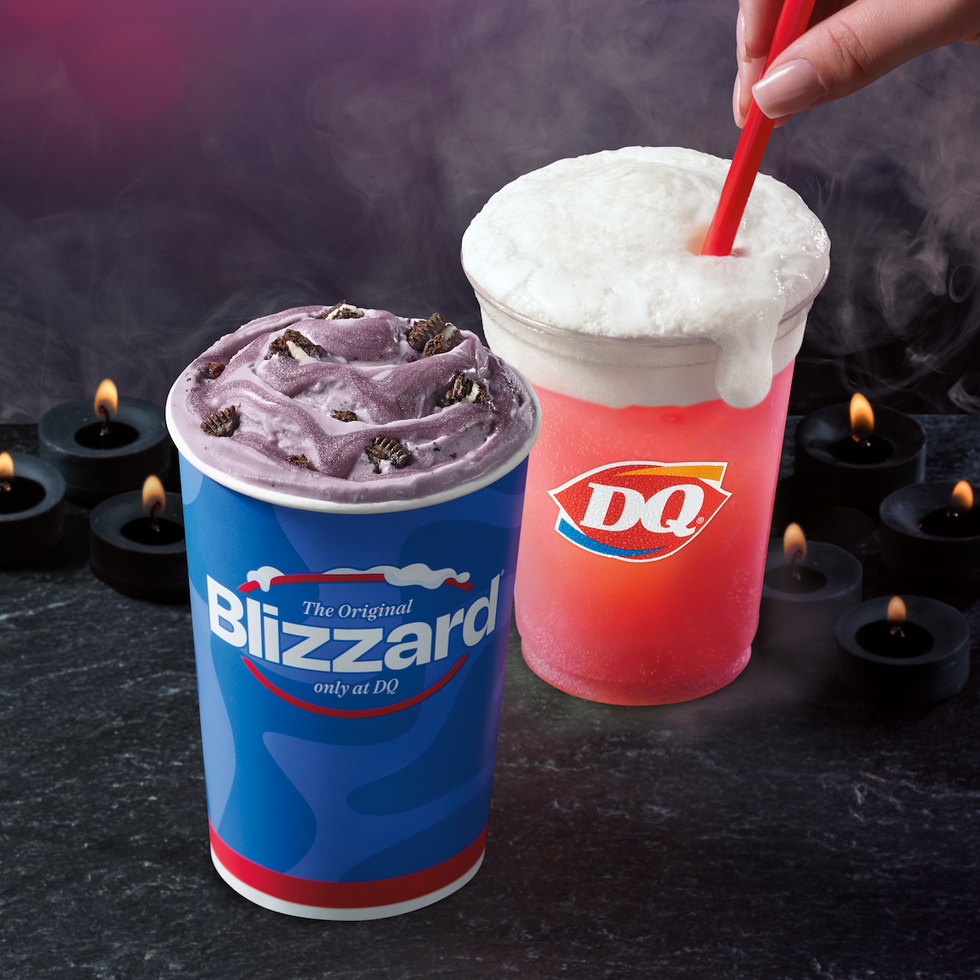 Two Dairy Queen treats: a Blizzard cup with purple dessert and a red drink with a straw, surrounded by candles and smoke. Two Dairy Queen treats: a Blizzard cup with purple dessert and a red drink with a straw, surrounded by candles and smoke.