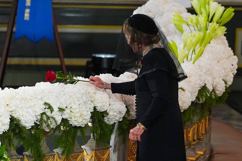 Queen Sonja placed a single rose stem on Harald's coffin
