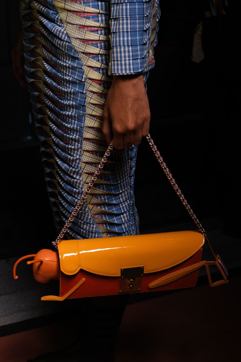 Insect-shaped accessories appeared throughout the Thom Browne show as well. Here, a delightfully oversized grasshopper clutch.