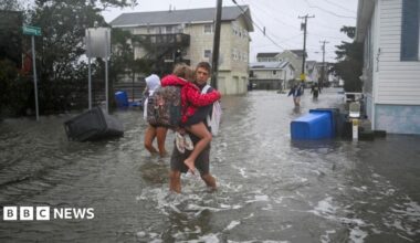 People walk in flooded streets in Surf City, New Jersey, on 26 September 2026