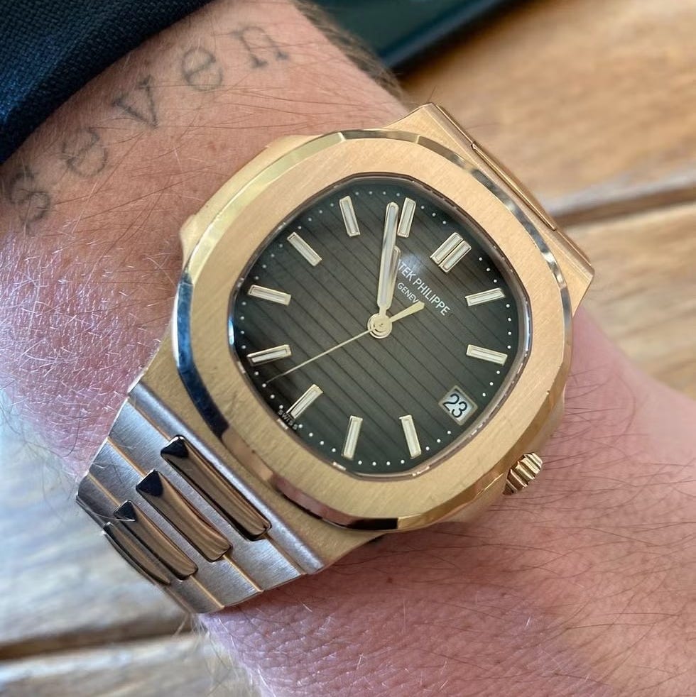 luxurious wristwatch with gold and stainless steel design on wrist with "seven" tattoo. luxurious wristwatch with gold and stainless steel design on wrist with "seven" tattoo.