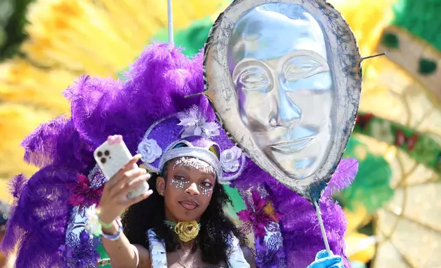 Participants take a selfie as they wait to walk in the West Indian Day Parade on Monday, Sept. 7, 2026, in the Brooklyn borough of New York. (AP Photo/Heather Khalifa)