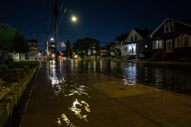 High tide floodwaters submerge a street in Howard Beach.