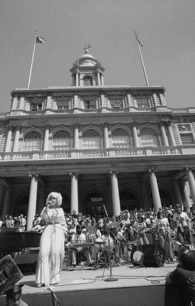 Dolly Parton sings in front of New York's City Hall on Monday, Aug. 22, 1978. The singer performed a lunchtime concert for New Yorkers after receiving a key to the city from New York's Mayor Ed Koch. (AP Photo/ Marty Lederhandler)