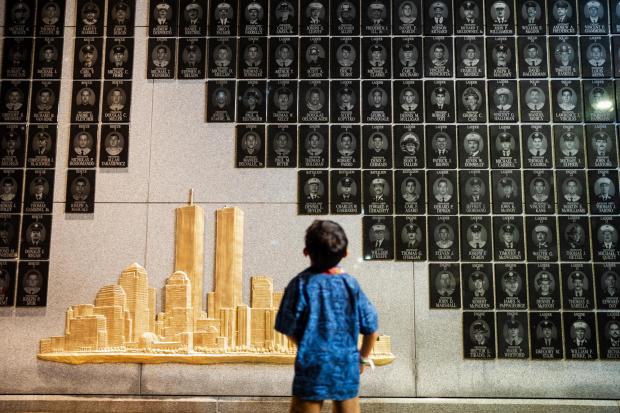 A young boy looks at the Brooklyn 9/11 Wall of Remembrance during the annual Candlelight Ceremony in Coney Island on the eve of the 25th anniversary of the Sept. 11 World Trade Center attacks, Thursday, Sept. 10, 2026, in New York. (AP Photo/Angelina Katsanis)