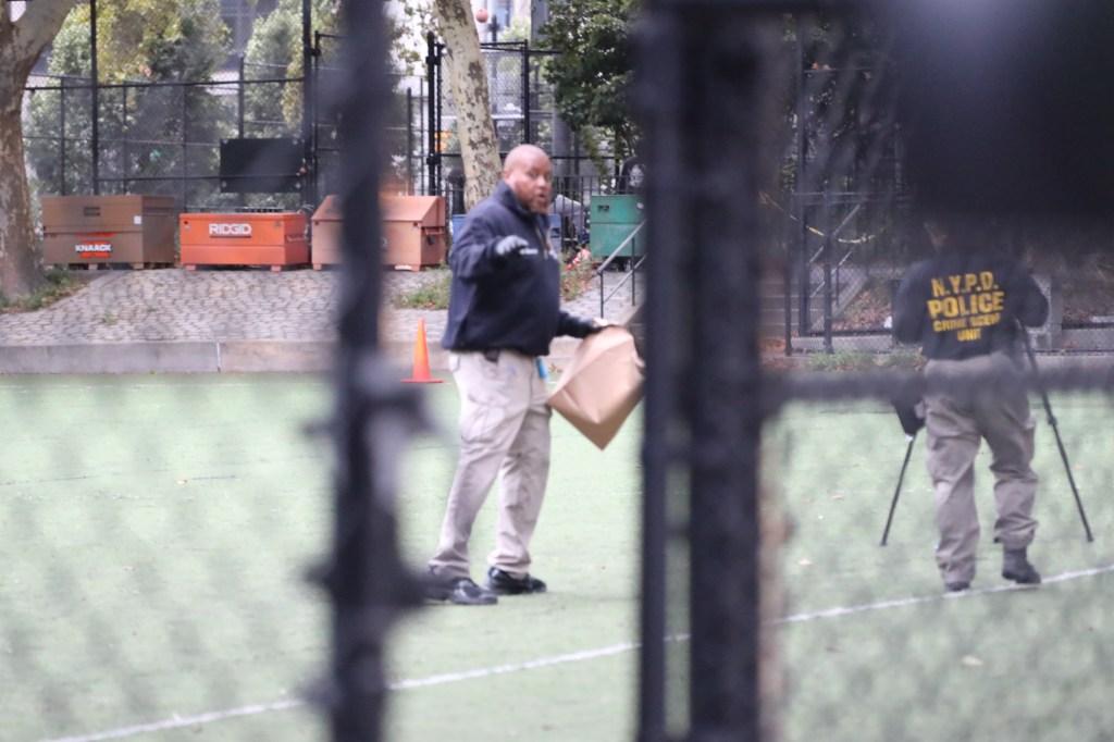 Two police officers in a park with tools.