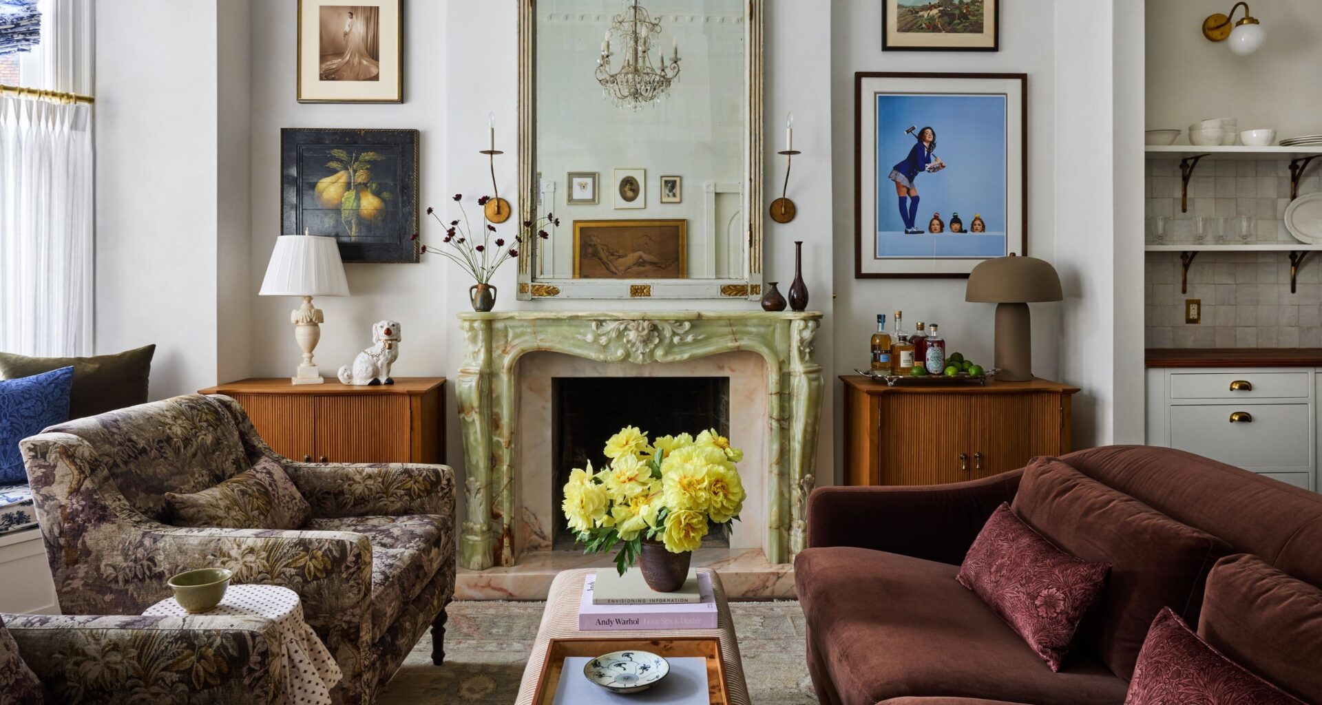 a vintage layered new york apartment living room with green marble fireplace, wooden cavinets in the alcoves and eclectic artwork