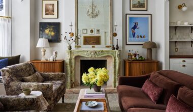 a vintage layered new york apartment living room with green marble fireplace, wooden cavinets in the alcoves and eclectic artwork