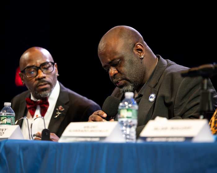 two men at table at brooklyn democratic party meeting
