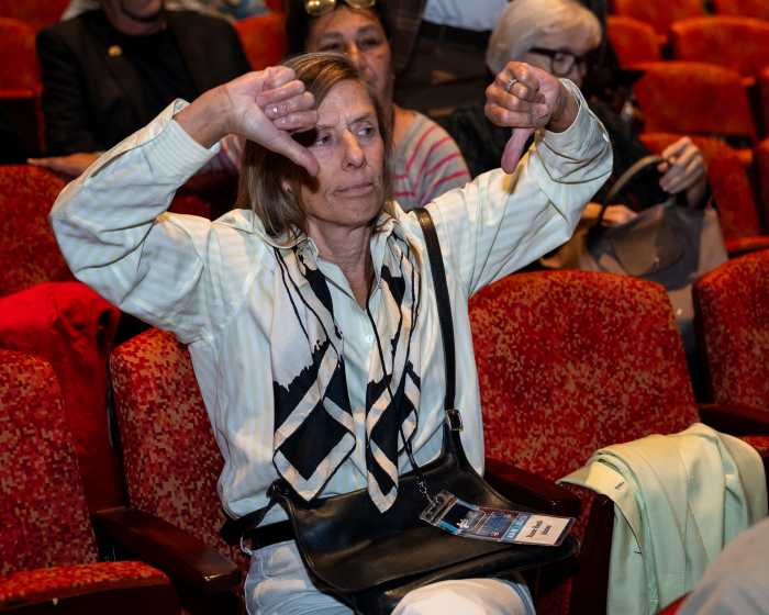 woman giving thumbs down in auditorium