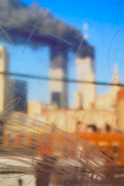 Taken from the subway with graffiti on the windows headed toward Chinatown before going back underground, Joe DiPetro took this photo of the burning Twin Towers in New York City on Sept. 11, 2001. (Photo by Joe DiPetro)
