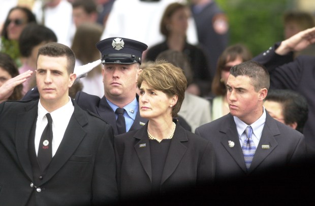 The family of fallen FDNY Firefighter Lt. Kevin Dowdell is pictured during Dowdell's funeral on April 19, 2002. From left, Dowdell's son, Patrick, his wife, Rose, and son, James. (John Roca for New York Daily News)