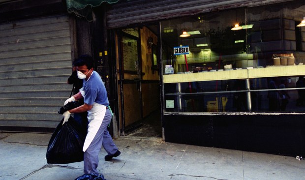 A restaurant worker takes out trash in Lower Manhattan amid cleanup efforts on Sept. 17, 2001. (Heidi Schumann for New York Daily News)
