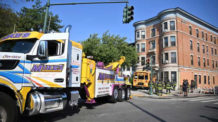 tow truck pulling crown heights bus