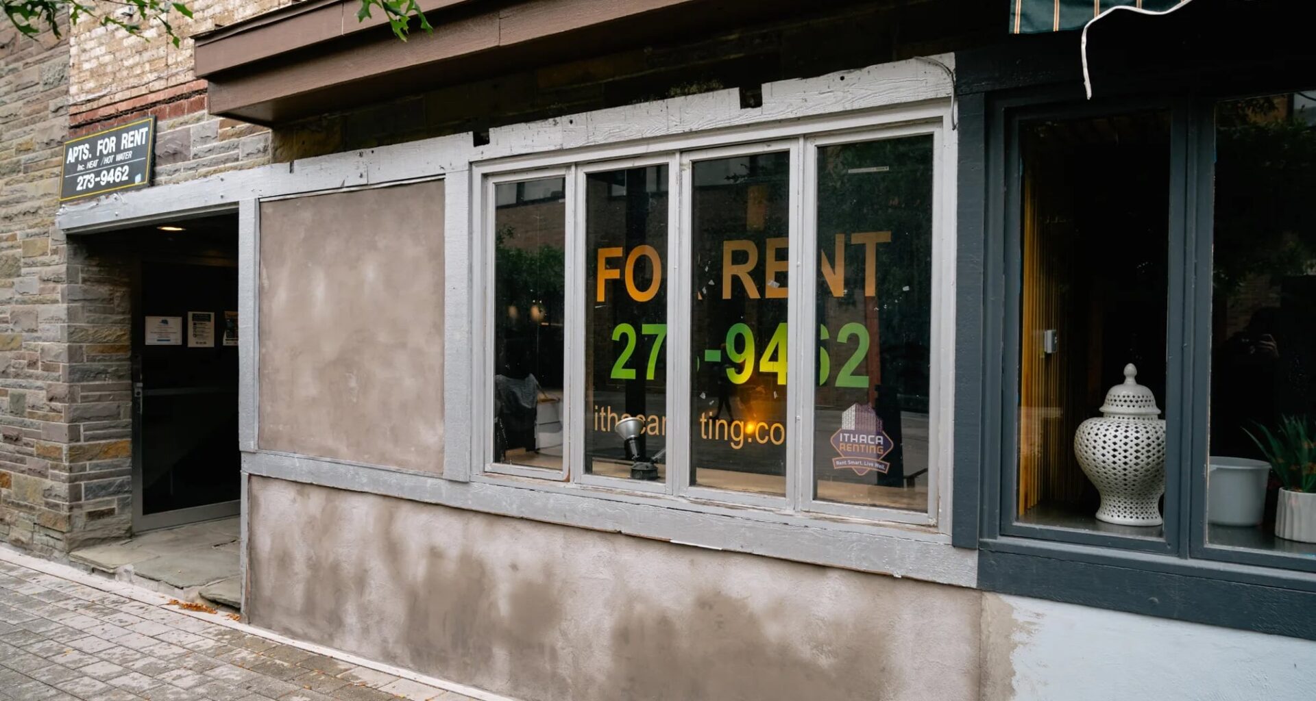 An empty storefront with a "For Rent" sign in the window.