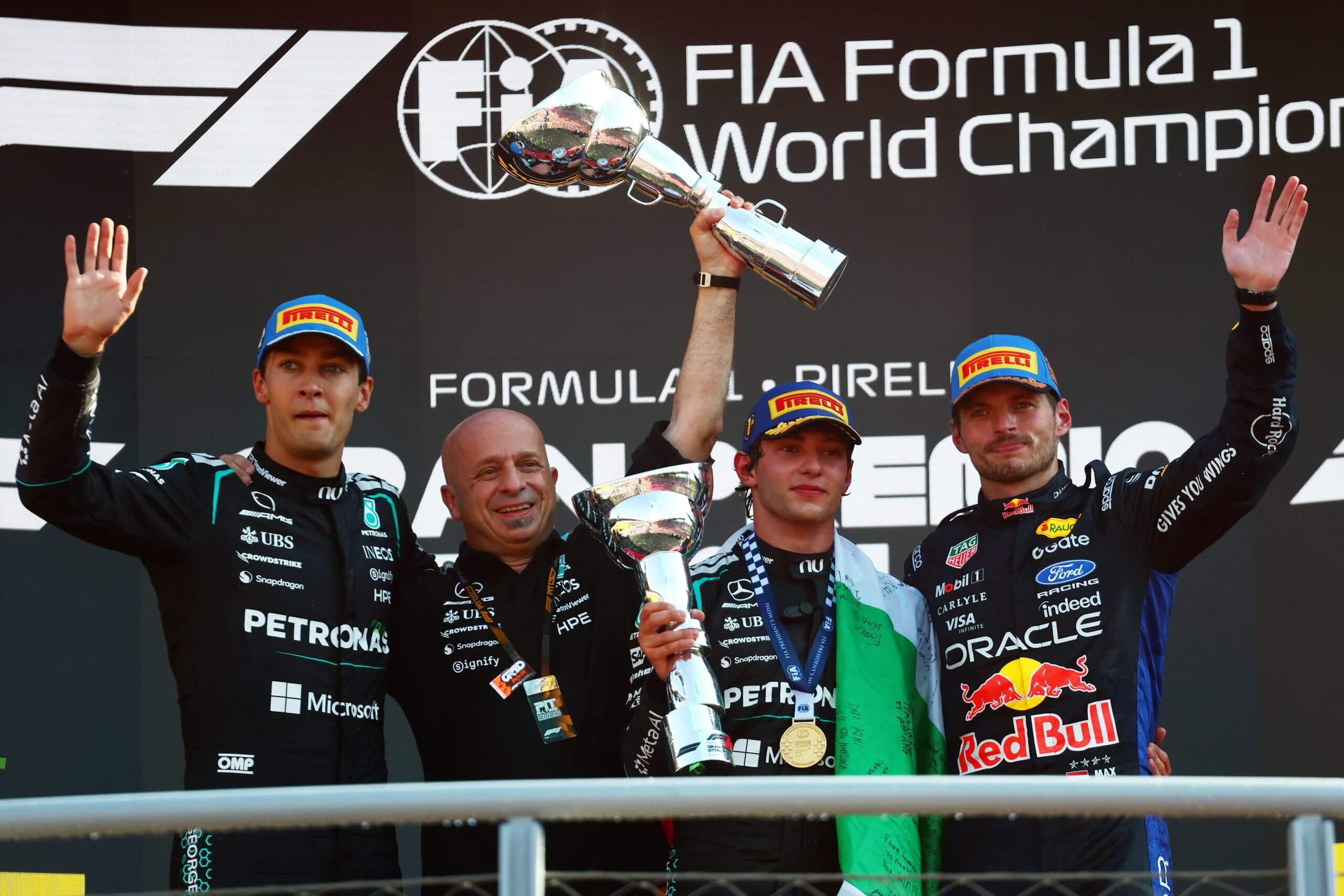 Kimi Antonelli, George Russell, Max Verstappen and Simone Resta, Mercedes' Deputy Technical Director, celebrate on the podium.