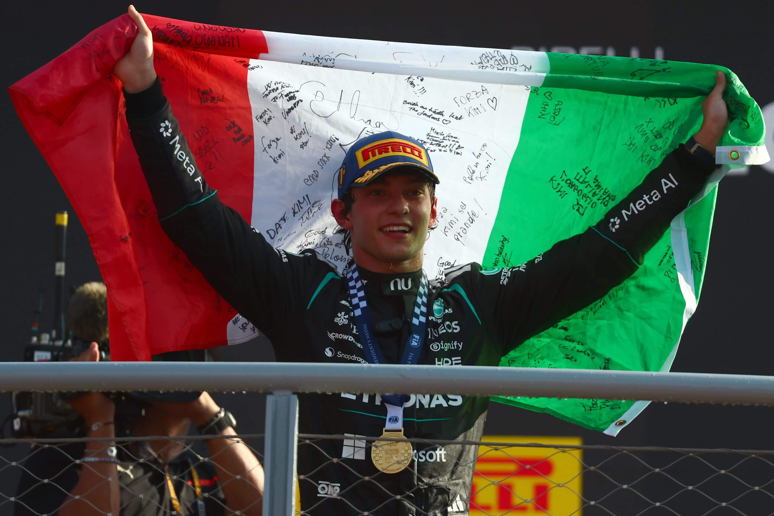 Kimi Antonelli holds aloft an Italian flag