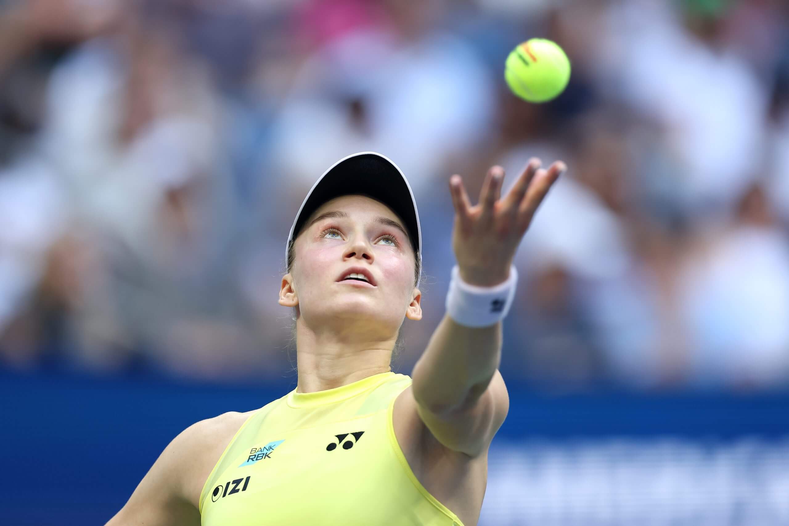 Elena Rybakina tosses a ball in the air as she prepares to serve.