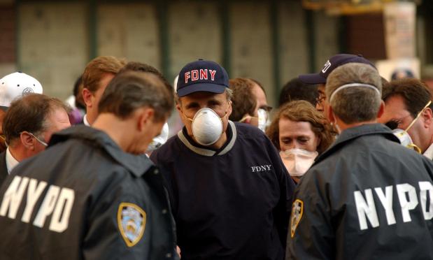 New York Mayor Rudy Giuliani wears a dust mask after a tour of the damage in Lower Manhattan on Sept. 12, 2001, in New York. (STAN HONDA / AFP via Getty Images)