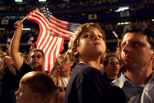 Jack Hord, 7, puts on a brave face while fans cheer the national anthem during pregame ceremonies at the Mets Braves game, Friday, September 21, 2001. According to neighbor J. Christopher Daly, Hord's father, Monty Hord, is missing, and was an employee at Cantor Fitzgerald which was located at the epicenter of the World Trade Center disaster. (Photo by Robert Gauthier/Los Angeles Times via Getty Images)