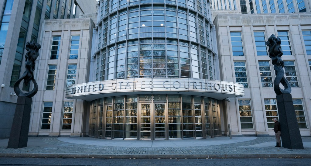 Exterior of the United States Courthouse building, featuring a curved glass facade and "UNITED STATES COURTHOUSE" sign above the entrance.