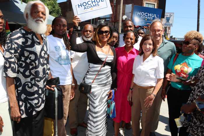 Trinidadian community and political activist Ernest Skinner, far left, with Gov. Kathy Hochul, second from right, front, and community residents in "Little Caribbean."