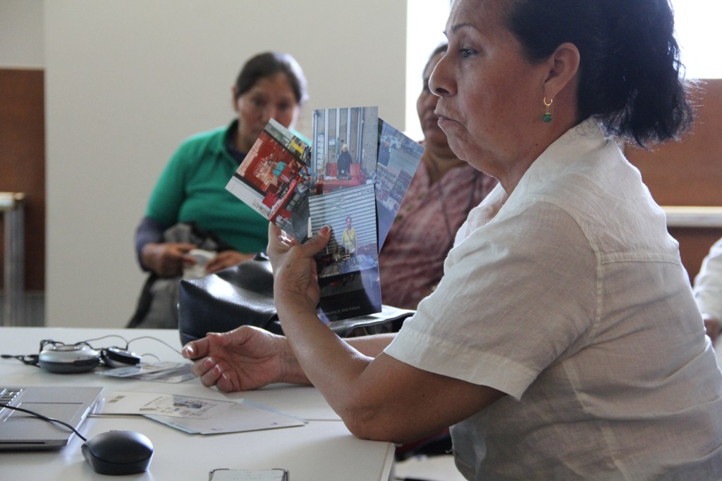 A street vendor shows photos she said could be used as evidence in the license application process at a Department of Consumer and Worker Protection hearing, Aug. 19, 2026.