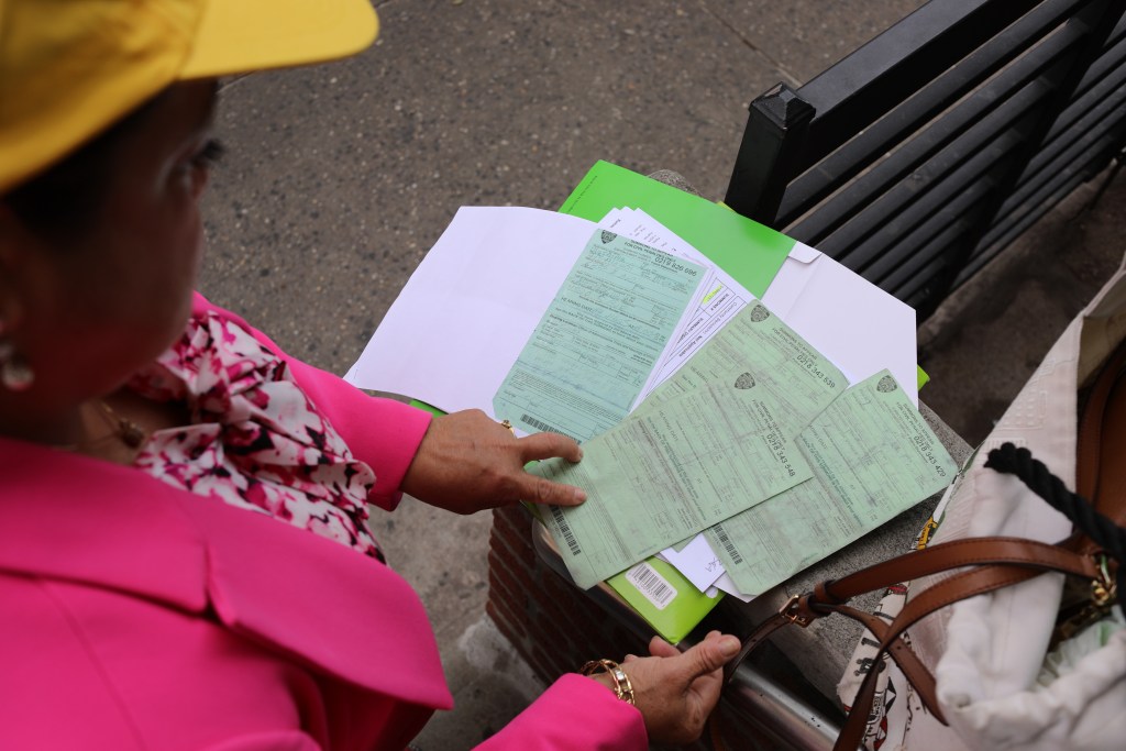 Luz Uruchima shows summonses she's received from law enforcement while vending, Sept. 3, 2026.