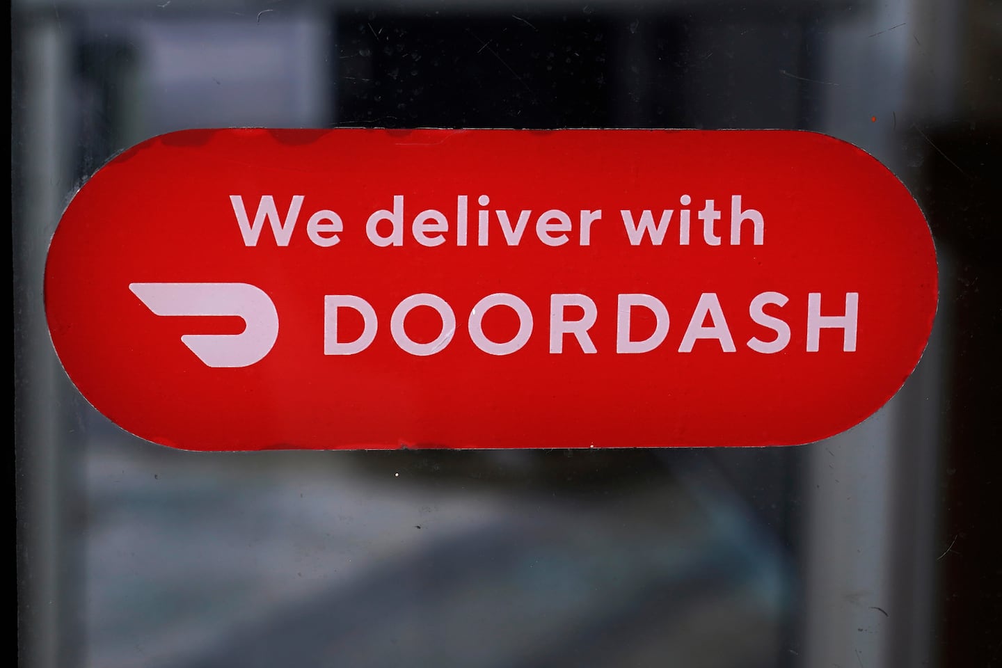 A DoorDash sign is posted on a door, Feb. 27, 2023, in Methuen, Mass.