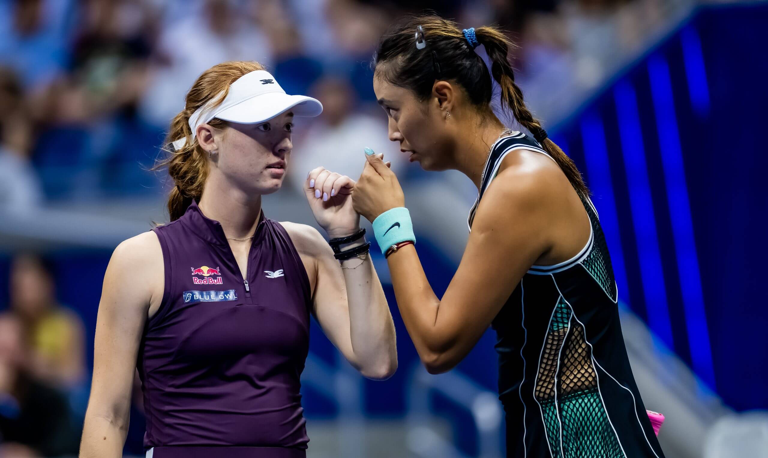 Maya Joint and Chan Hao-ching touch fists on a tennis court as they discuss tactics.