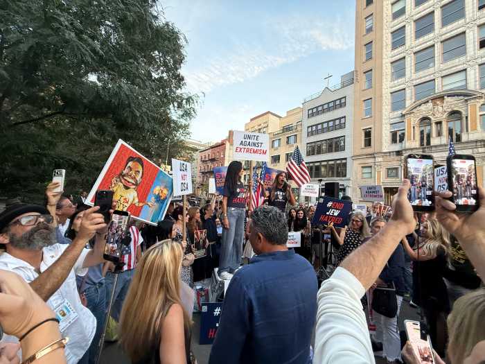people outside at a rally holdings signs