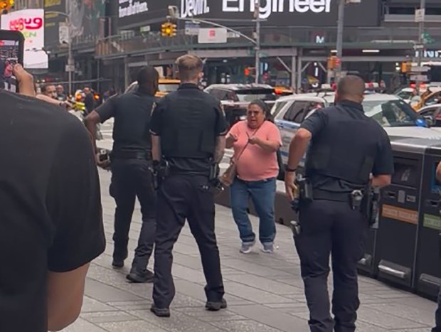 A woman (pictured here in pink) was shot by NYPD cops after refusing to drop two knives she was swinging as she approached them in Times Square Monday, Aug. 31, 2026, at Seventh Ave. and W. 43rd St. in Midtown Manhattan. (Courtesy of Jorge Disla)