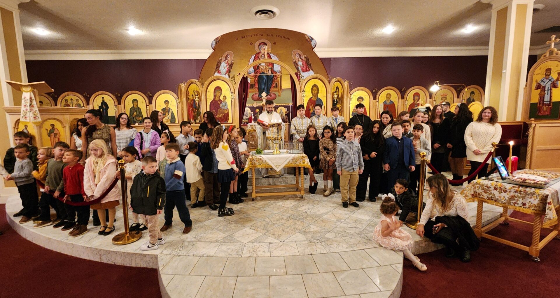 A commemorative photo of Fr. Vasileios Apostolidis with students and teachers during the Agiasmos blessing at Holy Trinity-St. Nicholas Church. Photo: TNH/Michael Kakias