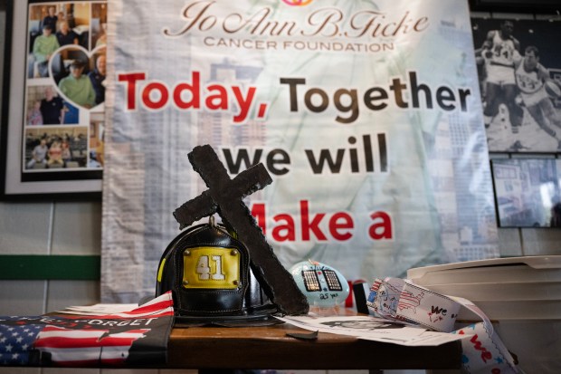 A NYFD fire helmet and a cross made from the steel of the World Trade Center are displayed during the annual 