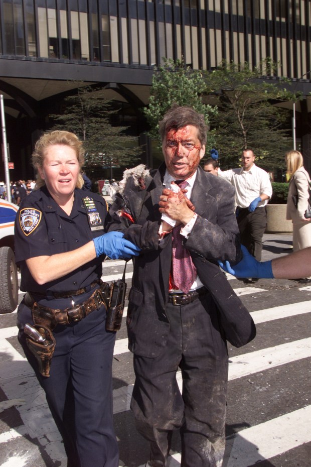 NYPD Police Officer Moira Smith helps Edward Nicholls, a broker at Aon, from the south tower of the World Trade Center minutes before its collapse on Sept. 11, 2001. She reentered the building to assist others in the evacuation and was killed. (Corey Sipkin / New York Daily News)
