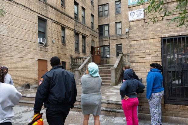 Displaced residents wait on the sidewalk after a fatal fire at 1484 Montgomery Ave. in the Bronx on Wednesday, Sept. 23, 2026. (Gardiner Anderson / New York Daily News)