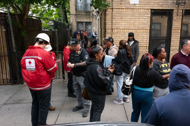 Displaced residents wait on the sidewalk after a fatal fire at 1484 Montgomery Ave. in the Bronx on Wednesday, Sept. 23, 2026. (Gardiner Anderson / New York Daily News)
