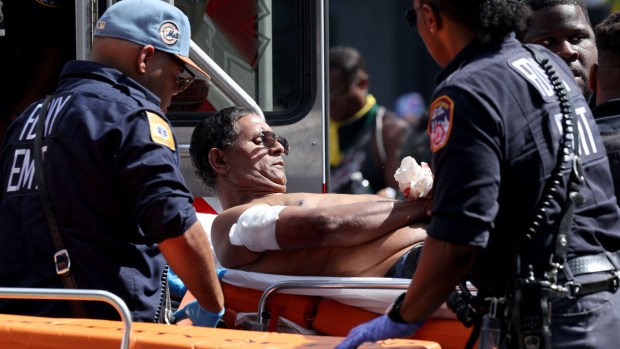 NYPD officers and EMS personnel remove an unidentified shooting victim from Eastern Parkway and Franklin Ave. in Brooklyn after someone opened fire and hit five people during the West Indian Day Parade on Monday, Sept. 2, 2024. (Luiz C. Ribeiro for New York Daily News)