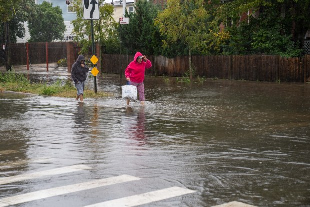 (Peolpe trudge through flood waters on Beach 69th Street) A powerful Nor'easter brought heavy, wind driven downpours to New York City, causing widespread flooding and bringing down trees on Saturday September 26, 2026. 0739. (Theodore Parisienne / New York Daily News)
