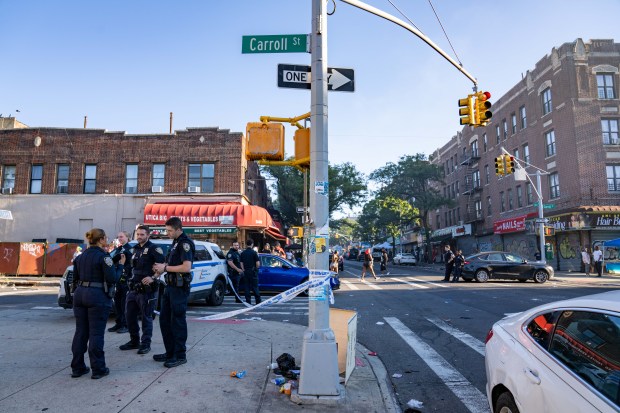 Police investigate after three people were stabbed on Utica Ave. and Carroll St. in Crown Heights on Monday morning.