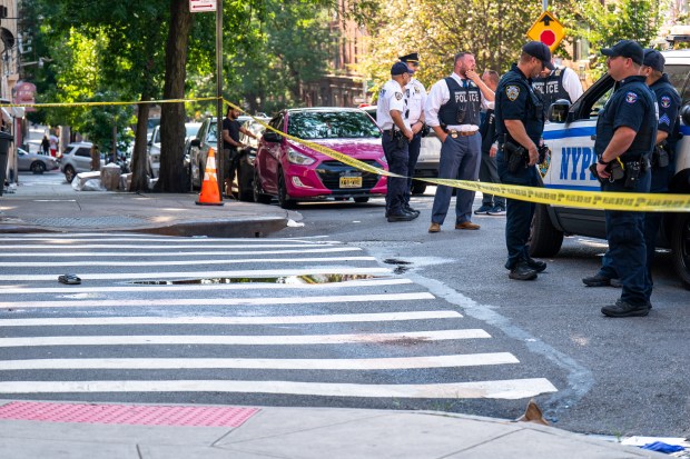 Police investigate after a man who fell unconscious in the street after fighting a rival early Saturday, Aug. 8, 20206, was run over by two passing vehicles, one a marked NYPD police cruiser, on College Ave. near E. 166th St. (Theodore Parisienne / New York Daily News)