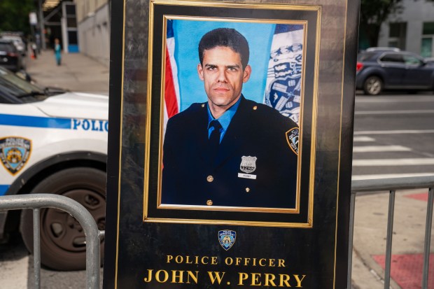 A photo of NYPD Officer John William Perry is pictured during a street renaming ceremony at Madison Ave. and E. 101st St. in Manhattan on Saturday, Sept. 5, 2026. (Theodore Parisienne / New York Daily News)