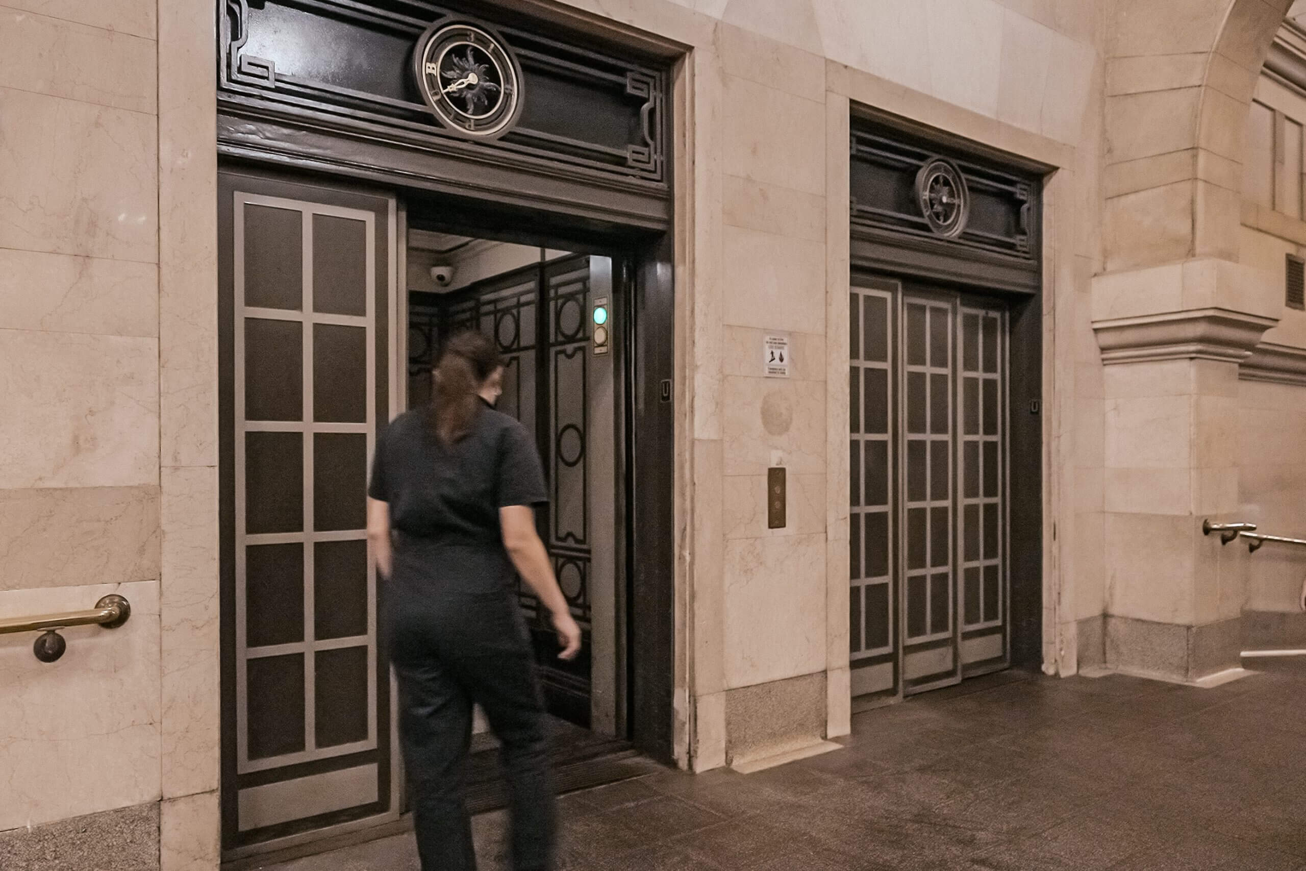 A woman walks into a lift up to a hidden tennis court.